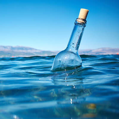 Empty corked wine bottle foating in the sea - message in a bottle